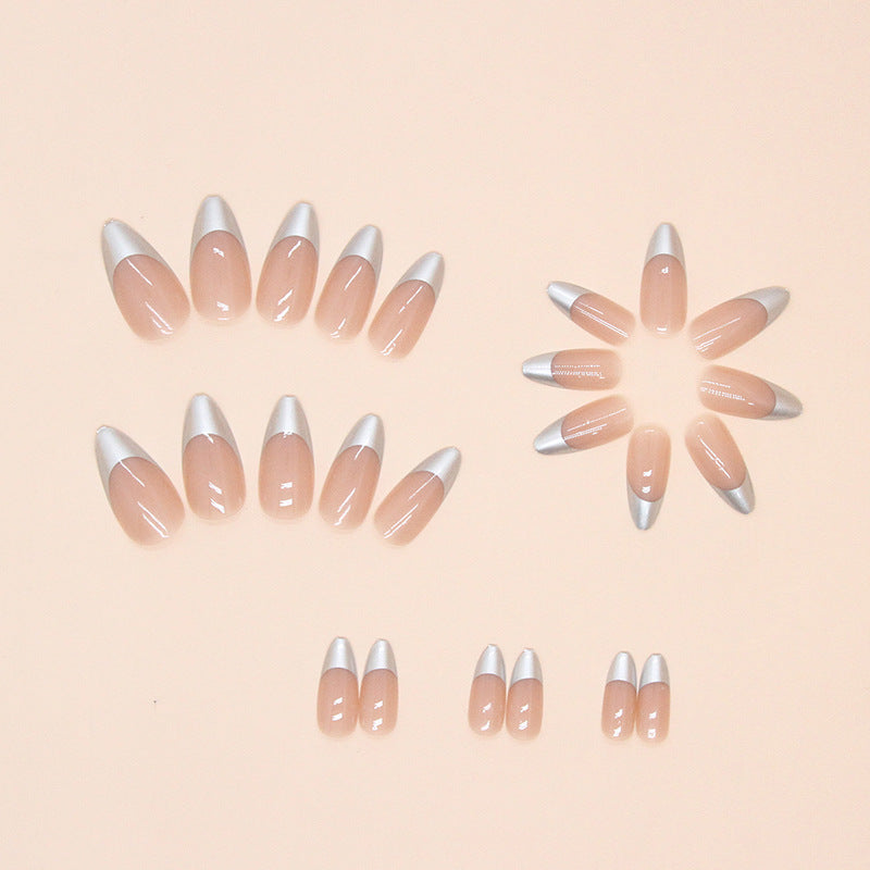 Set of beige nail extensions with silver tips on a beige background by Nailed It